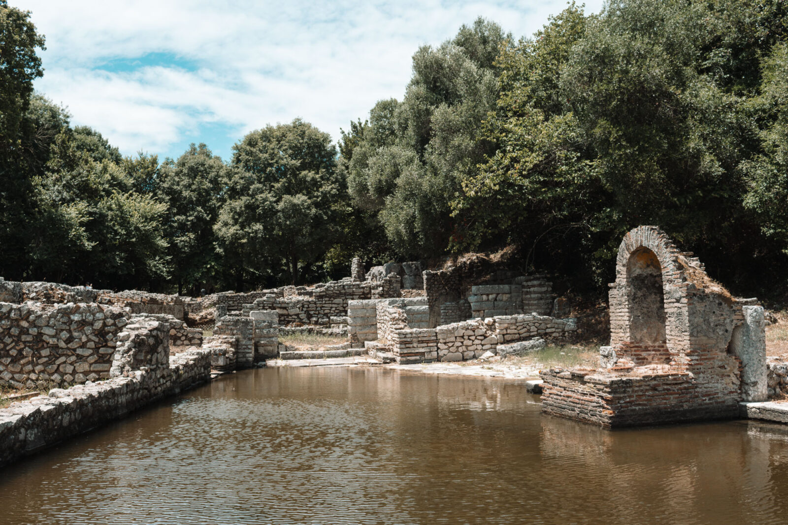 Ruinen mit gemauertem Bogen an einem überfluteten Becken in der antiken Stadt Butrint, Albanien